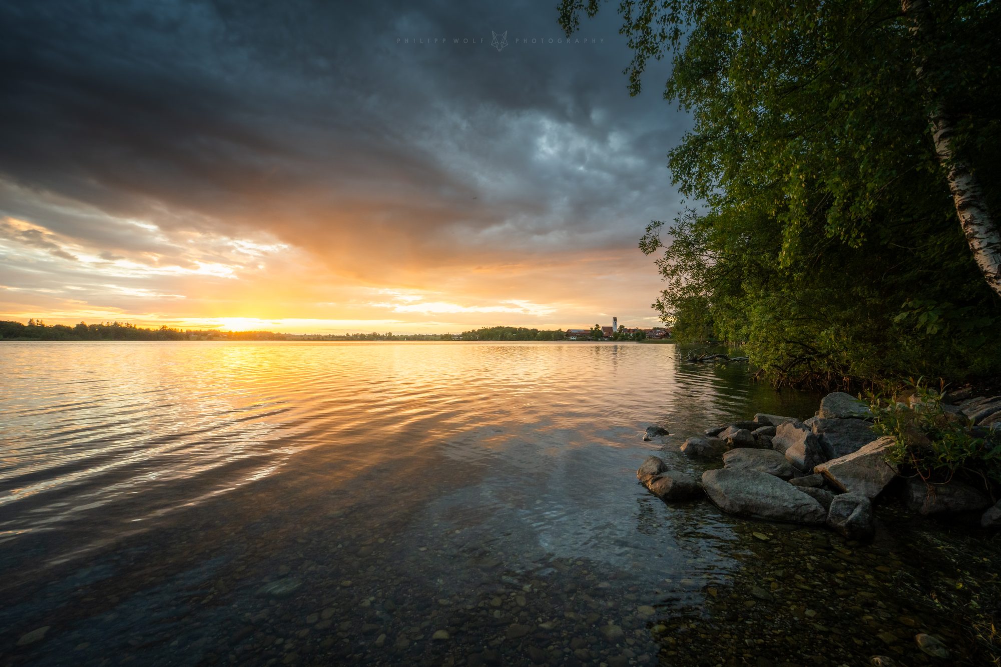 Bayerischer See bei Sonnenuntergang mit Dorfkirche am Ufer
